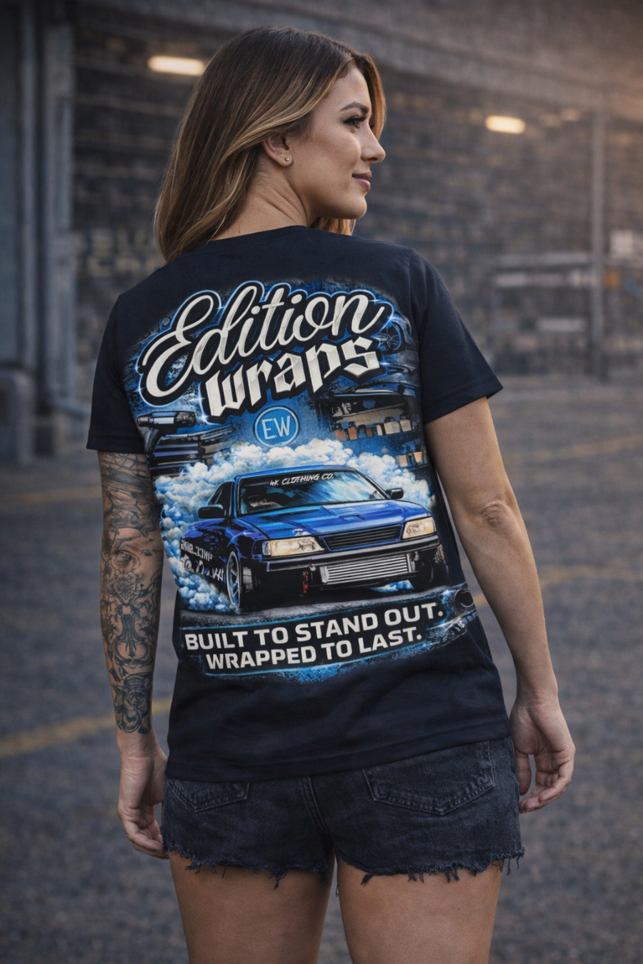 Woman wearing a black t-shirt with 'Edition Wraps' branding and car graphic.