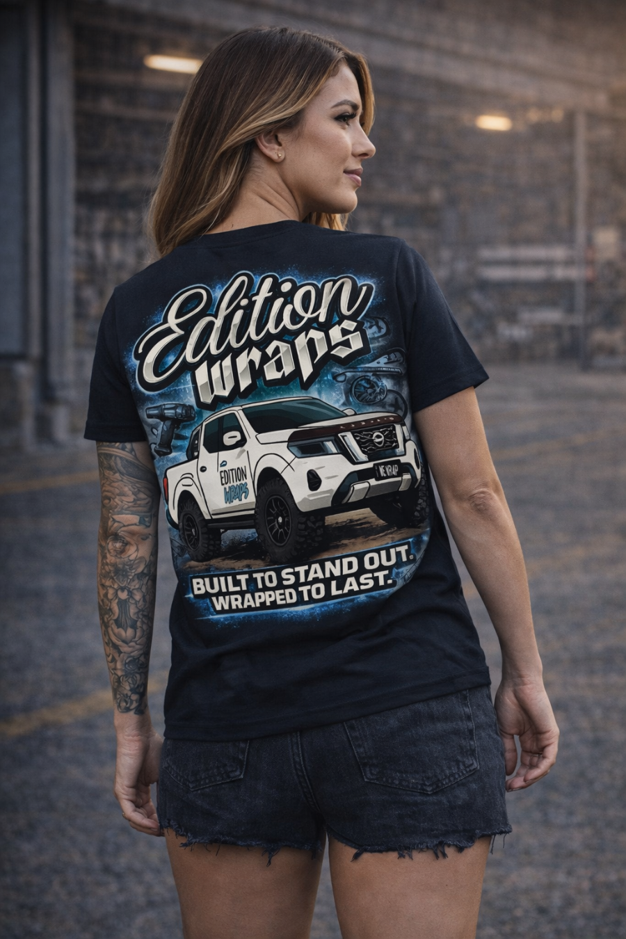 Woman wearing a black t-shirt with 'Edition Wraps' branding and a graphic of a white truck.